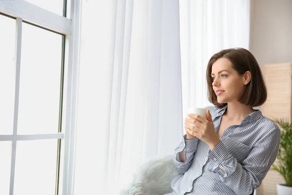 Morning of beautiful young woman drinking coffee near window — Stock Photo, Image
