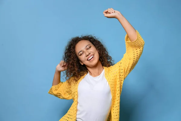 Happy dancing African-American woman on color background — Stock Photo, Image