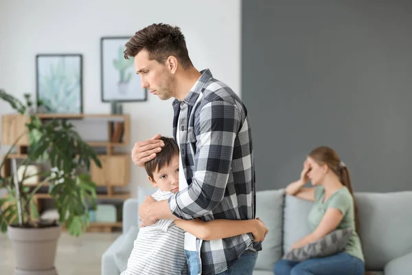 Man calming his son after family quarrel at home