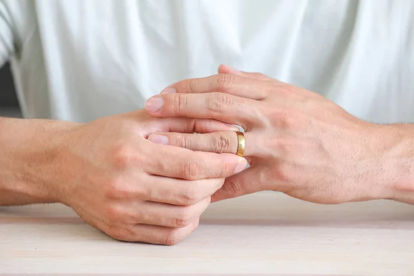 Hombre quitándose su anillo de bodas en casa, de cerca. Concepto de divorcio —  Fotos de Stock