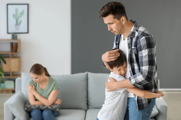 Man calming his son after family quarrel at home