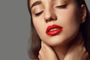 Gri arka plan üzerinde parlak ruj ile güzel genç kadın, closeup
