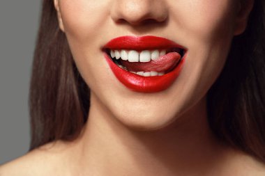 Gri arka plan üzerinde parlak ruj ile güzel genç kadın, closeup