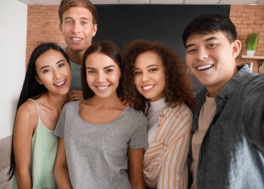 Mutlu arkadaşlar mutfakta birlikte yemek yaparken selfie çekiyor