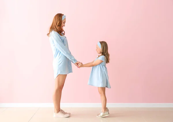 Mooie vrouw en haar kleine dochter in de buurt van Color Wall — Stockfoto