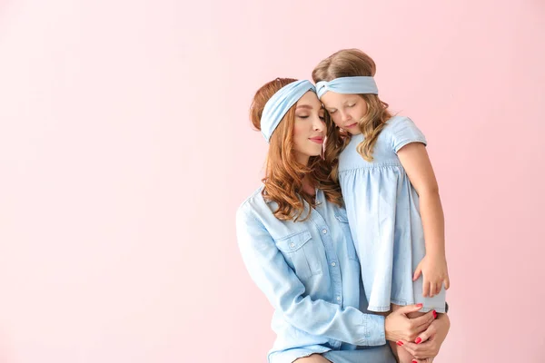 Beautiful woman and her little daughter on color background — Stock Photo, Image