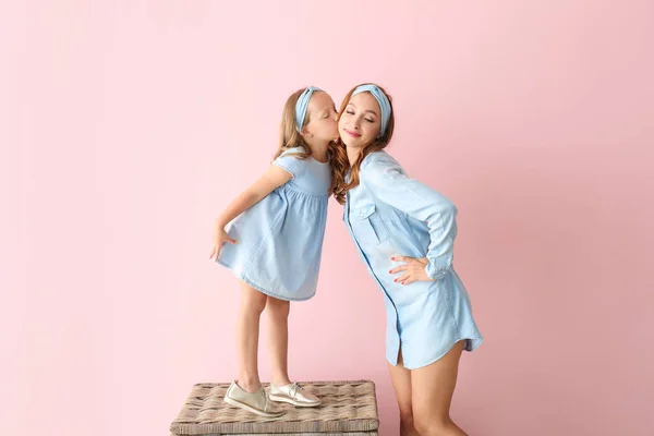 어린 소녀 키스 그녀의 어머니 에 색상 배경 — 스톡 사진