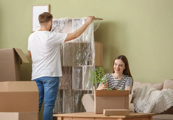 Young couple unpacking things after moving into new house — Stock Photo, Image