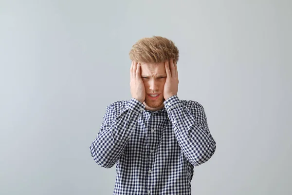Stressed young man on light background — Stock Photo, Image