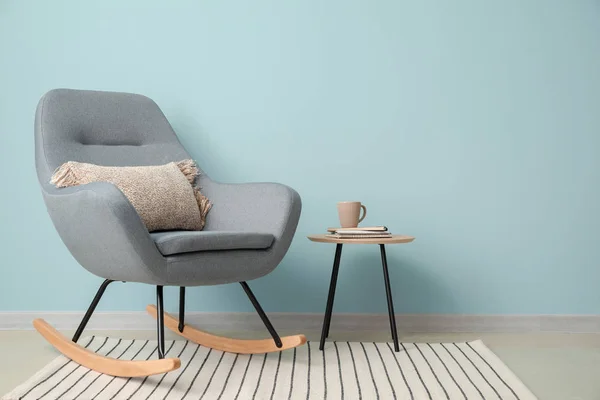 Fotel i stół w pobliżu ściany koloru — Zdjęcie stockowe
