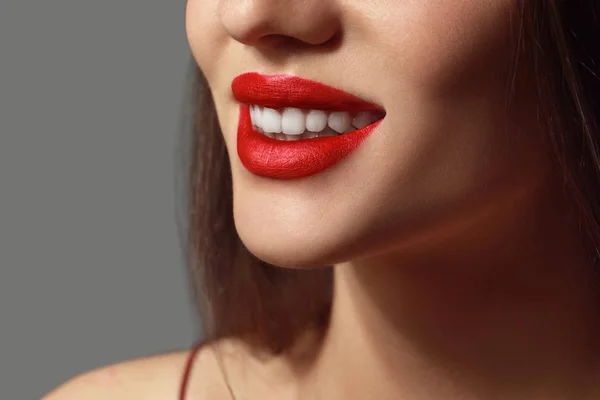 Mooie jonge vrouw met heldere lippenstift op grijze achtergrond, close-up — Stockfoto