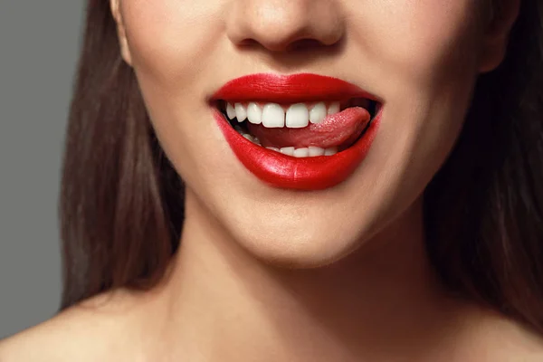 Mooie jonge vrouw met heldere lippenstift op grijze achtergrond, close-up — Stockfoto
