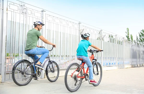 Happy father and son riding bicycles outdoors — Stock Photo, Image