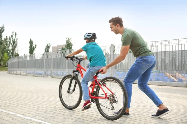 Ojciec uczy swojego syna, aby jeździć na rowerze na zewnątrz — Zdjęcie stockowe