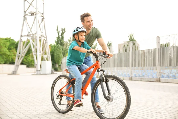 Ο πατέρας διδάσκει στο γιο του να ιππεύσει ποδήλατα σε εξωτερικούς χώρους — Φωτογραφία Αρχείου