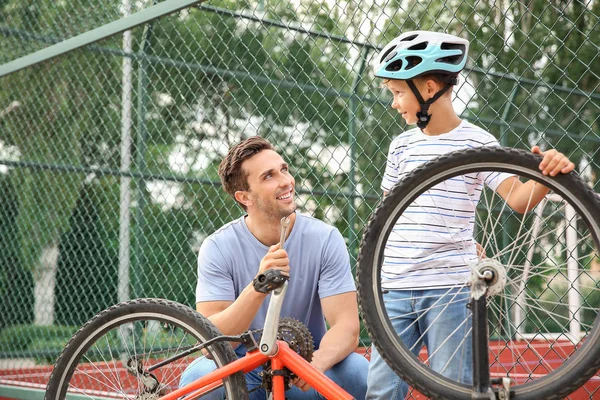 Ο πατέρας και ο γιος του επισκευάζουν ποδήλατα σε εξωτερικούς χώρους — Φωτογραφία Αρχείου