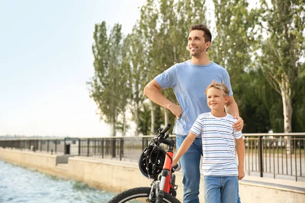 Vader en zijn kleine zoon met fiets buitenshuis — Stockfoto