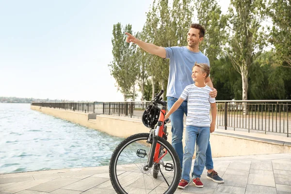 Батько і його маленький син з велосипедом на вулиці — стокове фото