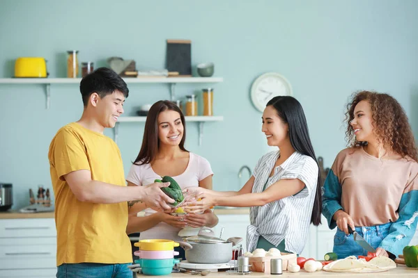 Glückliche Freunde kochen gemeinsam in der Küche — Stockfoto