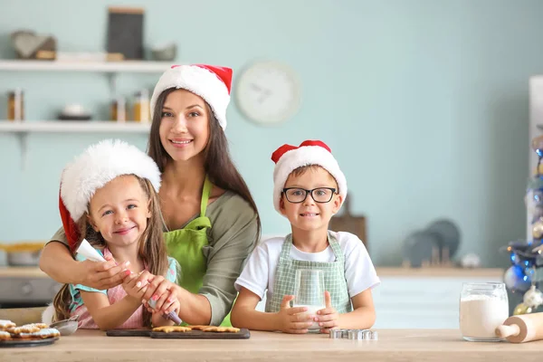 Mujer y sus hijos pequeños preparando galletas de Navidad en casa — Foto de Stock