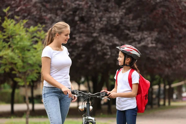 Woman and her little daughter with bicycle outdoors — Stock Photo, Image