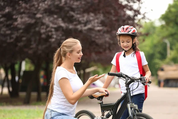 Woman and her little daughter with bicycle outdoors — Stock Photo, Image