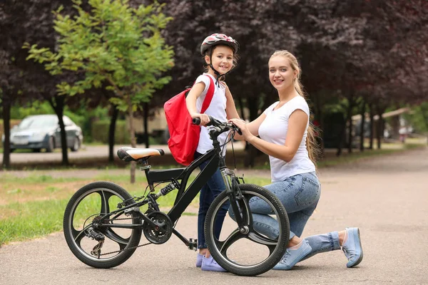 Mulher e sua filhinha com bicicleta ao ar livre — Fotografia de Stock