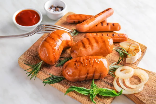 Tasty grilled sausages with herbs on wooden board — Stock Photo, Image