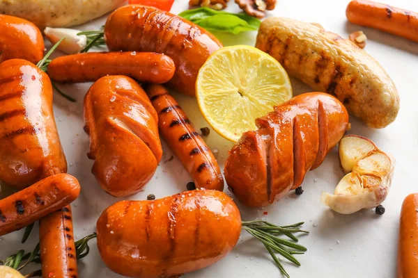 Assortment of tasty grilled sausages on light background — Stock Photo, Image