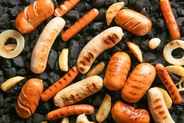 Tasty grilled sausages with vegetables on coals — Stock Photo, Image