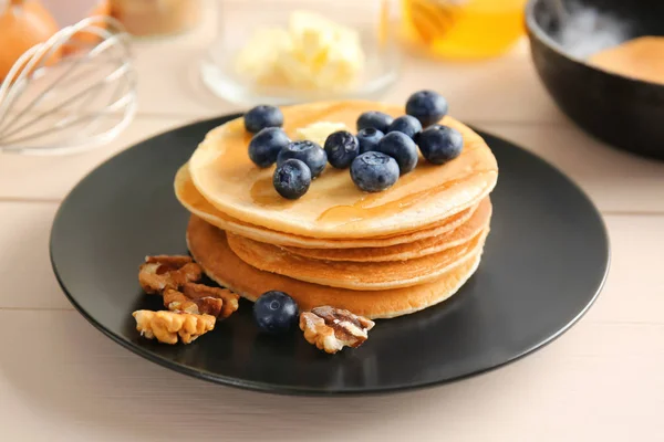 Assiette avec de savoureuses crêpes sur fond en bois — Photo