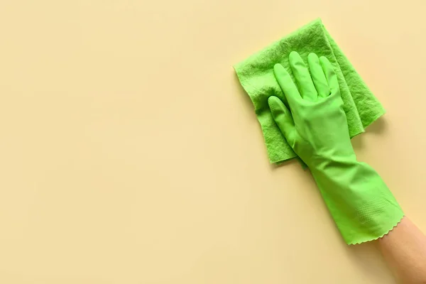 Female hand in glove holding cleaning rag on light background — Stock Photo, Image