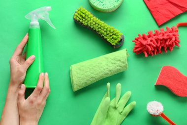 Renkli arka planda temizlik malzemeleri ile kadın elleri