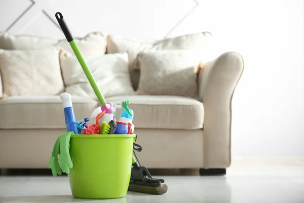 Bucket with cleaning supplies on floor in room — Stock Photo, Image