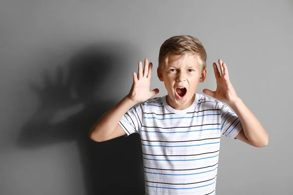 Портрет сердитого мальчика на сером фоне — стоковое фото