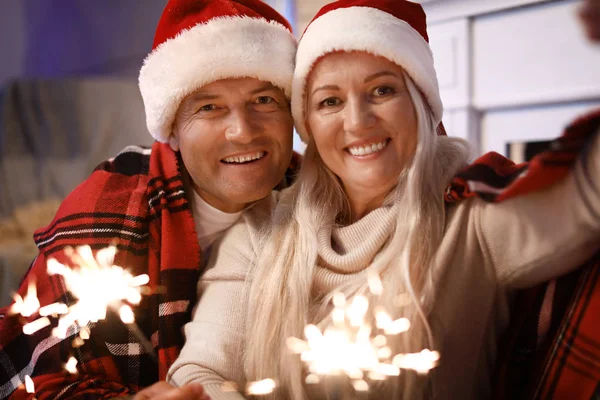 Happy äldre par med Christmas tomtebloss hemma — Stockfoto