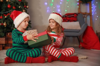 Sevimli küçük çocuklar evde Noel hediyeleri ile birbirlerine tebrik