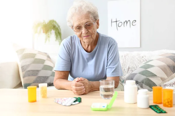 Ältere Frau mit Medikamenten zu Hause — Stockfoto