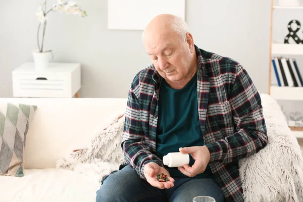 Anciano con pastillas en casa — Foto de Stock