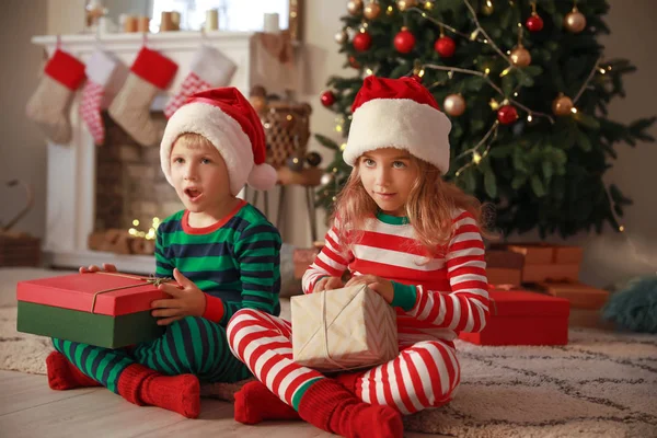 Cute little children with Christmas gifts at home — Stock Photo, Image