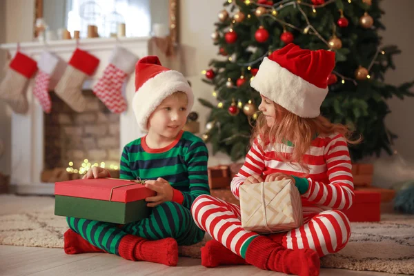 Niedliche kleine Kinder mit Weihnachtsgeschenken zu Hause — Stockfoto