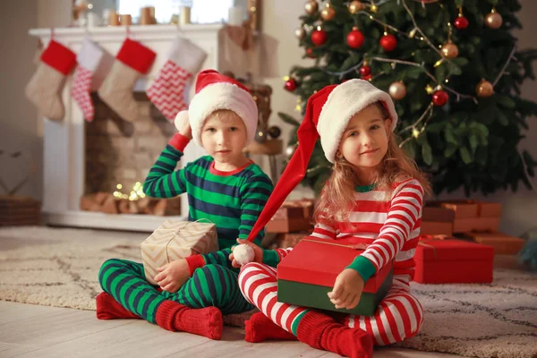 Niedliche kleine Kinder mit Weihnachtsgeschenken zu Hause — Stockfoto