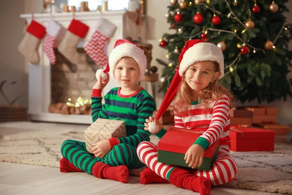 Lindos niños pequeños con regalos de Navidad en casa — Foto de Stock