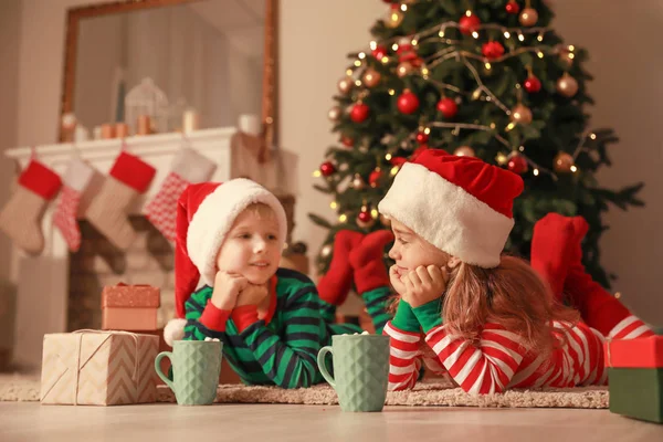 Söta små barn med koppar varm choklad på julafton hemma — Stockfoto