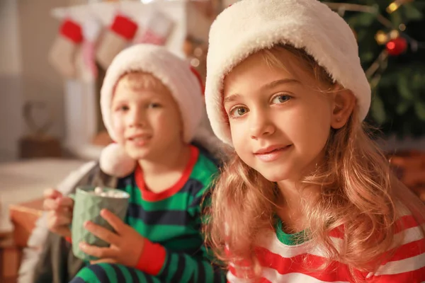 Petite fille mignonne avec frère le soir de Noël à la maison — Photo