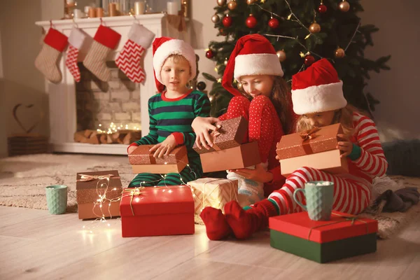 Söta små barn öppnar julklappar hemma — Stockfoto
