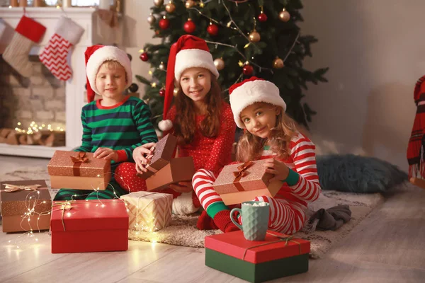 Niedliche kleine Kinder mit Weihnachtsgeschenken zu Hause — Stockfoto