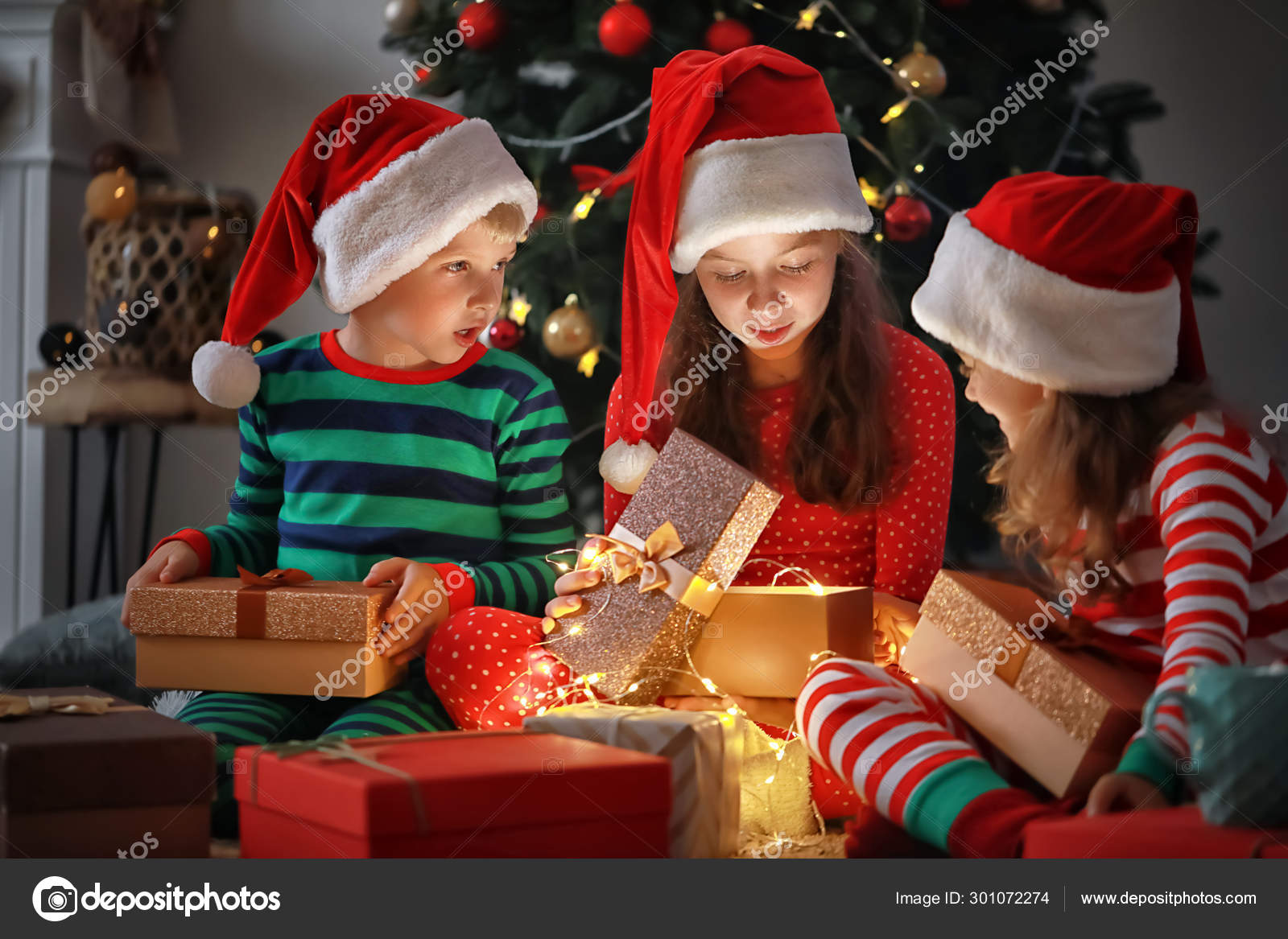 Cute little children opening magic Christmas gift at home Stock Photo by ©serezniy 301072274