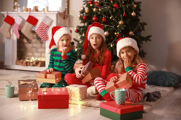 Kleine Kinder zu Hause mit Weihnachtsgeschenken überrascht — Stockfoto