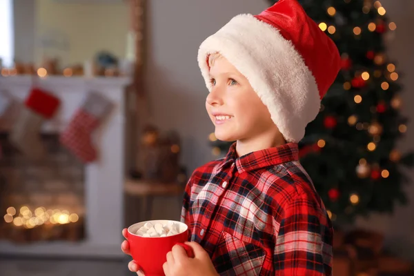 Mignon petit garçon avec du chocolat chaud la veille de Noël à la maison — Photo